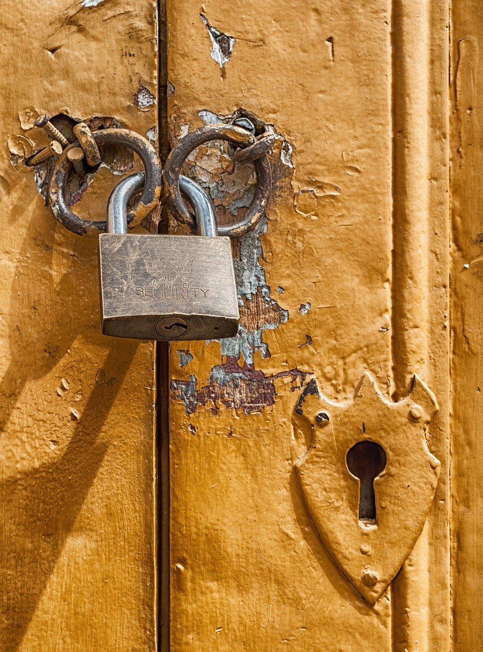Padlock on door with keyhole and peeling paint